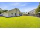 Large backyard with lush green grass, partial fencing, and a view of the home at 232 Moon Dance Ln, Summerville, SC 29483