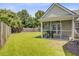 View of the backyard featuring a screened porch, lush green grass, and a wooden fence at 232 Moon Dance Ln, Summerville, SC 29483