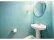 Stylish powder room with pedestal sink, oval mirror, and light blue wall paint at 234 S Lamplighter Ln, Summerville, SC 29486