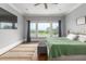 Bright bedroom featuring a large window with curtains, a TV, rug, and a bed with a green quilt at 2668 Crooked Stick Ln, Mount Pleasant, SC 29466