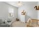Serene Bedroom featuring a crib, comfortable armchair, and whimsical decorations at 2722 Sunrose Ln, Johns Island, SC 29455