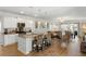 Open concept kitchen and living area with island seating, white cabinets, and hardwood floors at 2722 Sunrose Ln, Johns Island, SC 29455