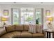 Comfortable seating area with a large sectional and view of the screened porch and backyard at 2722 Sunrose Ln, Johns Island, SC 29455