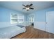 Bedroom with blue walls, wood floors, a ceiling fan, closet with mirror and two windows at 2847 Limestone Blvd, Charleston, SC 29414