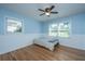 Bedroom with blue walls, wood floors, a ceiling fan, and two windows for natural light at 2847 Limestone Blvd, Charleston, SC 29414