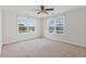 Bright bedroom features neutral walls, carpet, ceiling fan and two sunny windows with neighborhood views at 302 Mossy Wood Rd, Summerville, SC 29483