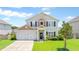 Charming two-story home with attached two car garage and a well-maintained, green front lawn at 302 Mossy Wood Rd, Summerville, SC 29483