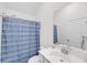 Well-lit bathroom with a large mirror, vanity, and a shower with a blue and white patterned curtain at 3020 River Vista Way, Mount Pleasant, SC 29466