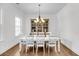 Elegant dining room with hardwood floors, a white dining set, and a decorative chandelier fixture at 3020 River Vista Way, Mount Pleasant, SC 29466
