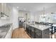 A modern kitchen with a large island, granite countertops, stainless steel appliances, and dark cabinets at 3020 River Vista Way, Mount Pleasant, SC 29466