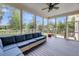 A large screened-in porch with comfortable seating, offering views of the backyard at 3020 River Vista Way, Mount Pleasant, SC 29466