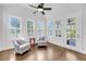 Bright sunroom featuring hardwood floors, multiple windows, a ceiling fan, and two armchairs at 3020 River Vista Way, Mount Pleasant, SC 29466