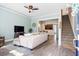 Bright living room featuring light-colored sofa, TV, staircase, and a view into the adjacent dining area at 312 Barberry St, Summerville, SC 29483