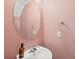 Charming half-bathroom featuring a pedestal sink, oval mirror, and pink walls at 312 Kelsey Blvd, Wando, SC 29492
