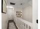 Hallway features white banisters, leading to an open landing with modern light fixture and wall art at 312 Kelsey Blvd, Wando, SC 29492