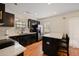 Modern kitchen featuring dark cabinets, stainless steel appliances, and a breakfast bar with quartz countertops at 312 Kelsey Blvd, Wando, SC 29492