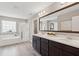 Bright bathroom with a double vanity, separate shower, and tub under a large window at 3274 Arrow Arum Dr, Johns Island, SC 29455