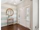 Bright foyer with a round mirror, striped accent wall, hardwood floors, and a white front door at 3274 Arrow Arum Dr, Johns Island, SC 29455