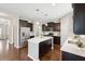 Modern kitchen featuring dark wood cabinets, stainless steel appliances, and a bright white quartz countertop island at 3274 Arrow Arum Dr, Johns Island, SC 29455