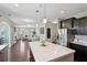 Open concept view of kitchen and living room, showcasing stainless steel appliances, an island, and hardwood floors at 3274 Arrow Arum Dr, Johns Island, SC 29455