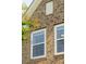 Close-up of brick facade with white-trim windows and a wall vent, adding architectural detail to the home's exterior at 3274 Arrow Arum Dr, Johns Island, SC 29455