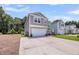 Two-story house showcasing a spacious concrete driveway, landscaping, and an attached garage at 331 Saddlewood Dr, Charleston, SC 29414