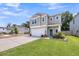 Charming two-story home with manicured lawn, landscaping, concrete driveway, and an attached garage at 331 Saddlewood Dr, Charleston, SC 29414