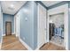 Hallway with blue walls and white trim, with a doorway to a laundry room featuring modern washer and dryer at 331 Saddlewood Dr, Charleston, SC 29414