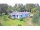 Charming one-story home with a blue exterior and a lush, green lawn surrounded by mature trees at 365 W Pine St, Varnville, SC 29944