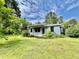 Inviting front yard with green grass surrounding a cozy home, landscaped with flowering bushes and plants at 365 W Pine St, Varnville, SC 29944
