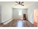 Sunny living room featuring new floors, a ceiling fan, and a vintage fireplace, with easy access to bathroom and other rooms at 365 W Pine St, Varnville, SC 29944
