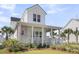 Charming two-story home boasts a welcoming front porch, lush landscaping, and a patriotic American flag at 3769 Summerton St, Mount Pleasant, SC 29466