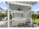 Relaxing hot tub sheltered by a pergola with a fan, surrounded by lush landscaping and privacy screens at 3769 Summerton St, Mount Pleasant, SC 29466