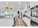 Modern kitchen with hardwood floors, stainless steel appliances, white cabinetry and kitchen island at 3769 Summerton St, Mount Pleasant, SC 29466