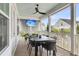 Relaxing screened porch featuring ceiling fan, TV, dining table, and beautiful outdoor scenery at 3769 Summerton St, Mount Pleasant, SC 29466