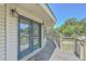 Exterior doors leading to a spacious wooden balcony with scenic views of surrounding trees at 395 Summerset Ln, Summerville, SC 29483