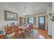 A formal dining room features hardwood floors, a traditional chandelier, and a large window for natural light at 395 Summerset Ln, Summerville, SC 29483