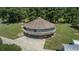 Aerial view of a unique round house, featuring a wraparound deck and a spacious paved driveway at 395 Summerset Ln, Summerville, SC 29483