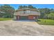Exterior shot of a round house with a garage featuring a brick exterior and driveway at 395 Summerset Ln, Summerville, SC 29483