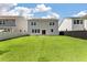 Expansive backyard featuring lush green lawn, light siding, and sliding glass door access from the house at 425 W Respite Ln, Summerville, SC 29483