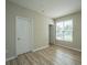 Neutral bedroom showcasing wood-look floors, a window, and a paneled door at 45 Scyamore Ave # 623, Charleston, SC 29407