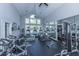 Bright gym with workout equipment, high ceilings, ceiling fans, and large windows overlooking trees and greenery at 45 Scyamore Ave # 623, Charleston, SC 29407
