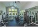 Bright gym with workout equipment, high ceilings, ceiling fans, and large windows overlooking trees and greenery at 45 Scyamore Ave # 623, Charleston, SC 29407