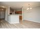 Open-concept living space with kitchen bar, dining area, and hardwood floors at 45 Scyamore Ave # 623, Charleston, SC 29407