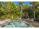 Inviting community pool with lounge chairs, a brick fireplace, and lush landscaping at 45 Scyamore Ave # 623, Charleston, SC 29407