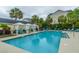 Sparkling swimming pool with lounge chairs, cabanas, and palm trees, surrounded by community buildings at 45 Scyamore Ave # 623, Charleston, SC 29407