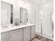 Modern bathroom featuring double sinks, white cabinets, and a glass-enclosed shower at 5000 Paddy Field Way, Ladson, SC 29456