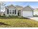 Charming single-story home featuring a well-manicured lawn and attached two car garage at 5000 Paddy Field Way, Ladson, SC 29456