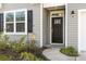 Close up of the front door with sidelight, window, and green landscaping at 5000 Paddy Field Way, Ladson, SC 29456