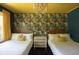 Charming bedroom with bright floral wallpaper, two beds, and stylish overhead lighting at 5010 Converse St, North Charleston, SC 29405